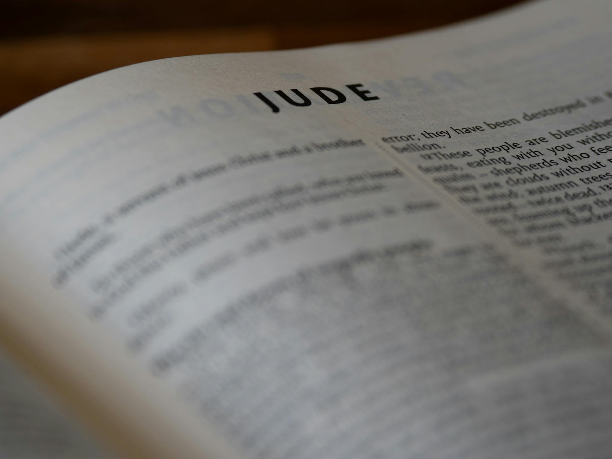A close-up shot of a Bible opened to the Book of Jude, highlighting the text vividly.